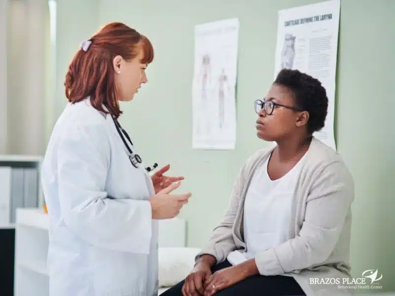 A white doctor is talking to a black patient