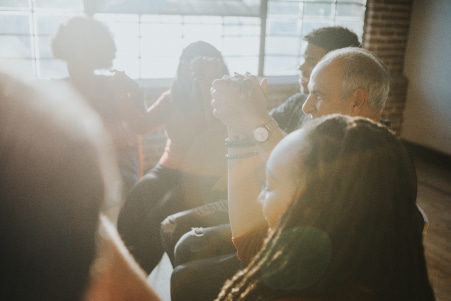 Group of diverse people holding hands up in the air | Houston, TX Detox Treatment Centers | Brazos Place